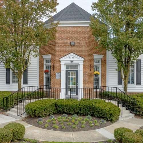 a brick building with a fence and trees in front of it
