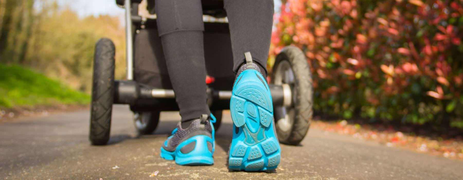 woman pushing a stroller in park