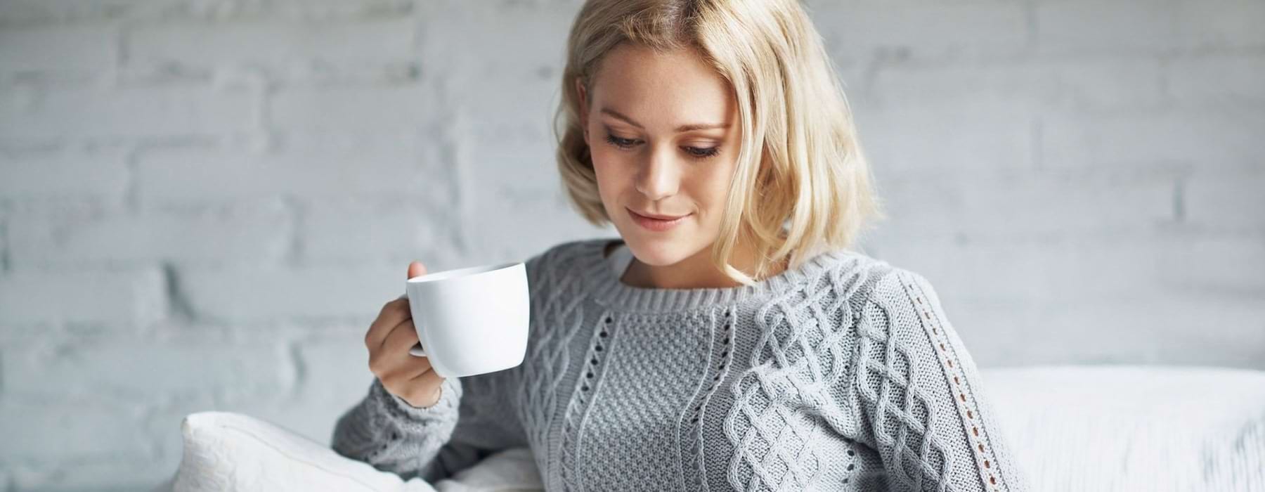 woman holding a white cup